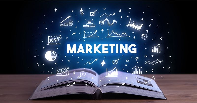 Open book displaying a marketing concept with icons symbolizing different marketing strategies and ideas.